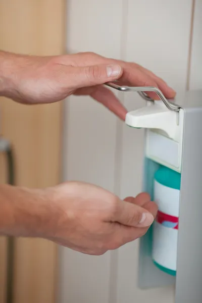 Médicos usan dispensador de desinfectante — Foto de Stock