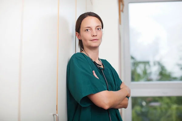 Chirurgien féminin fatigué avec stéthoscope dans le mur — Photo