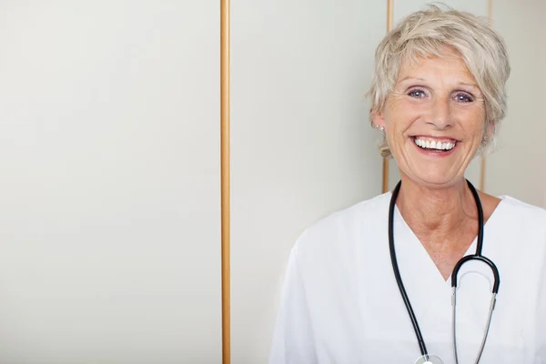 Senior Female Doctor Against Wall In Hospital — Stock Photo, Image