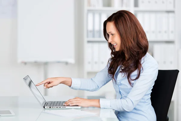 Businesswoman pointing to her laptop — Stock Photo, Image