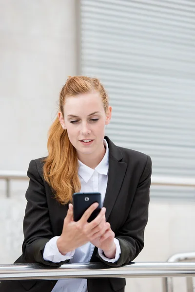 Attraktive Frau schaut aufs Smartphone — Stockfoto