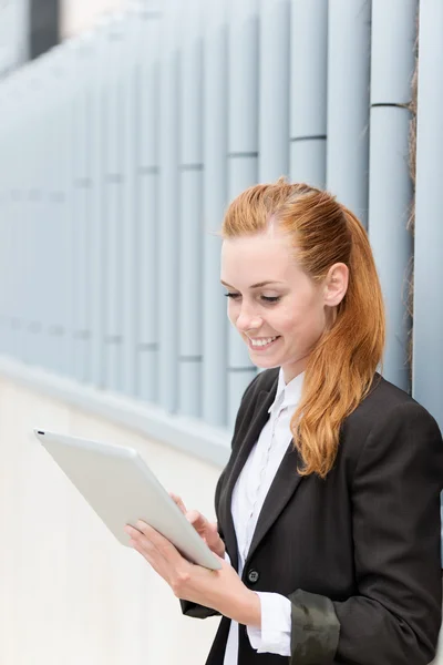 Empresaria sonriente leyendo tablet pc — Foto de Stock