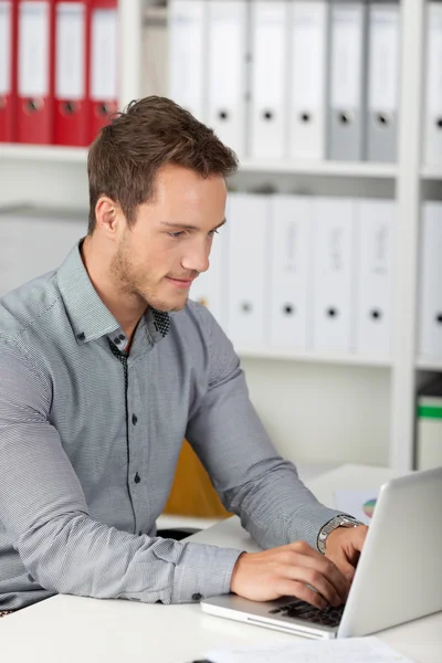 Vue latérale sur l'homme d'affaires en utilisant un ordinateur portable — Photo