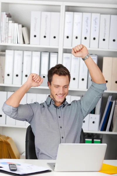 Empresário feliz torcendo por laptop na mesa — Fotografia de Stock