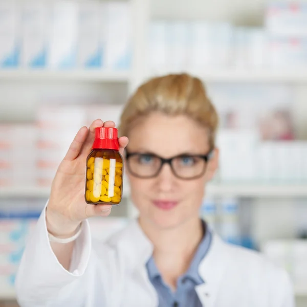 Wazig apotheker houden tabletten in fles — Stockfoto