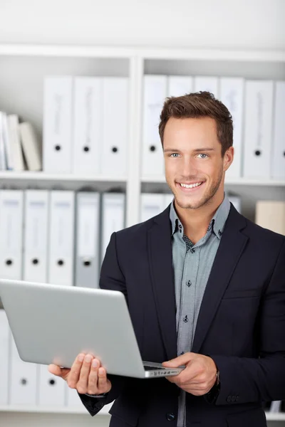 Smiling Businessman With Laptop In Office Stock Picture