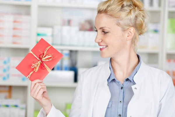 Kobieta farmaceuta patrząc na Kupony prezentowe — Zdjęcie stockowe