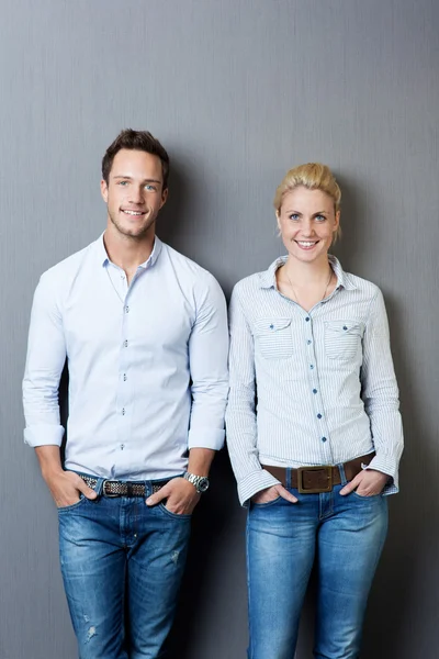 Retrato de pareja sonriente contra fondo gris —  Fotos de Stock