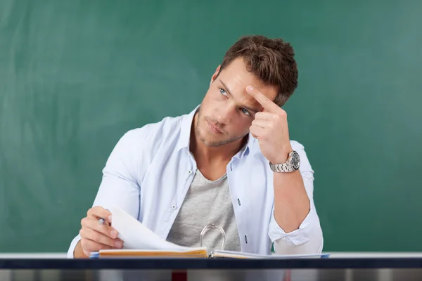 Studente premuroso guardando lontano davanti alla lavagna — Foto Stock