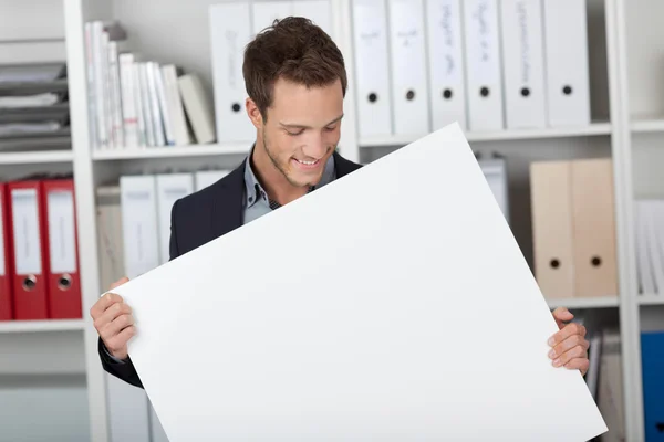 Zakenman kijken naar leeg teken op kantoor — Stockfoto