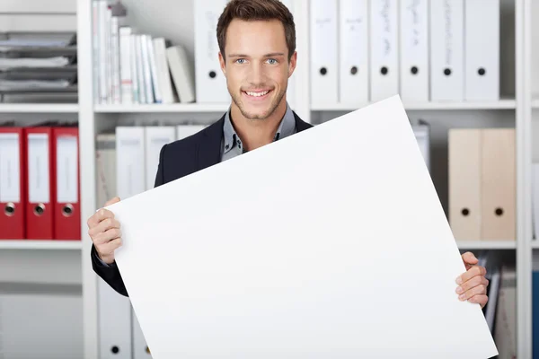 Zakenman bedrijf leeg teken op kantoor — Stockfoto