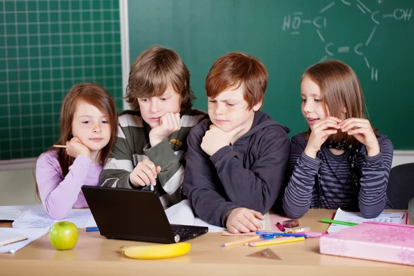 Crianças em idade escolar olhando para um laptop — Fotografia de Stock