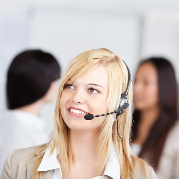 Nachdenklicher Kundendienstmitarbeiter mit Headset in der Hand — Stockfoto