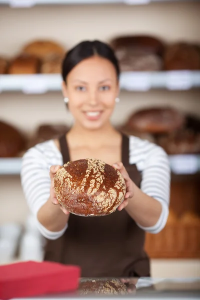 Lachende verkoopster brood in een bakkerij tonen — Stockfoto