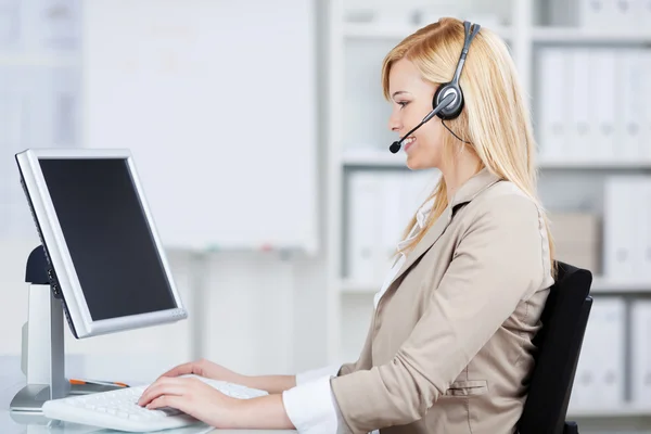 Mujer de negocios usando auriculares en el escritorio de negocios —  Fotos de Stock