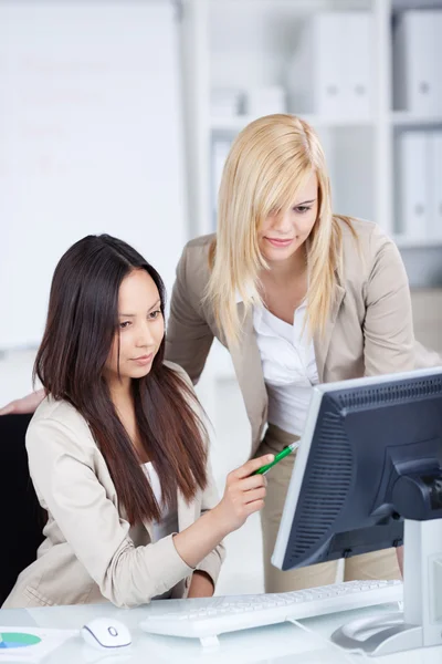 Женщина-сотрудник, работающая вместе за компьютером — стоковое фото