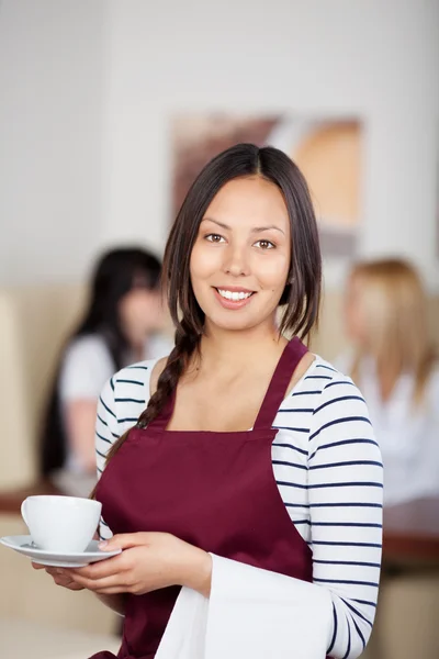 Teenager-Kellnerin hält Kaffeetasse im Café — Stockfoto