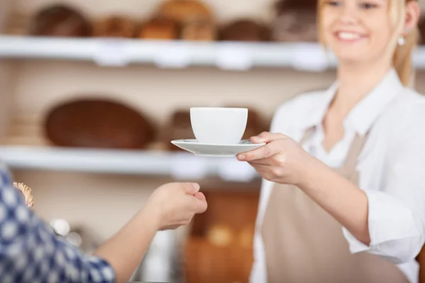 Fille dans un café servant une tasse de café — Photo