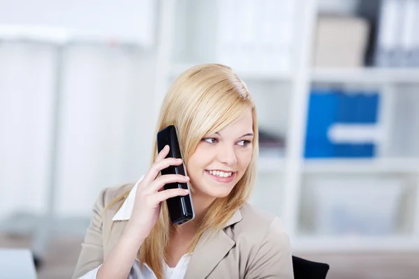 Empresária usando telefone sem fio enquanto olha para longe — Fotografia de Stock