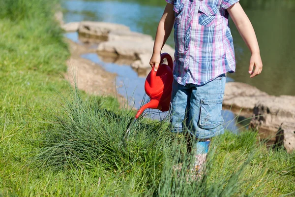 Little girl playing with a watering can — Stock Photo, Image