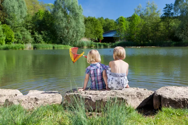 Two little girls fishing at the lake — Stock Photo, Image