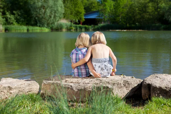 Two loving little sisters at the lake — Stock Photo, Image