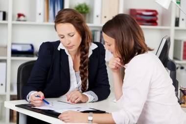 Female co-workers working on a project clipart