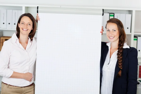 Businesswomen giving a flip chart presentation