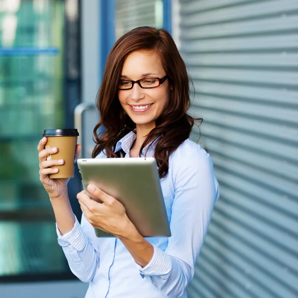 Frau trinkt Kaffee und liest ihren Tablet-PC — Stockfoto