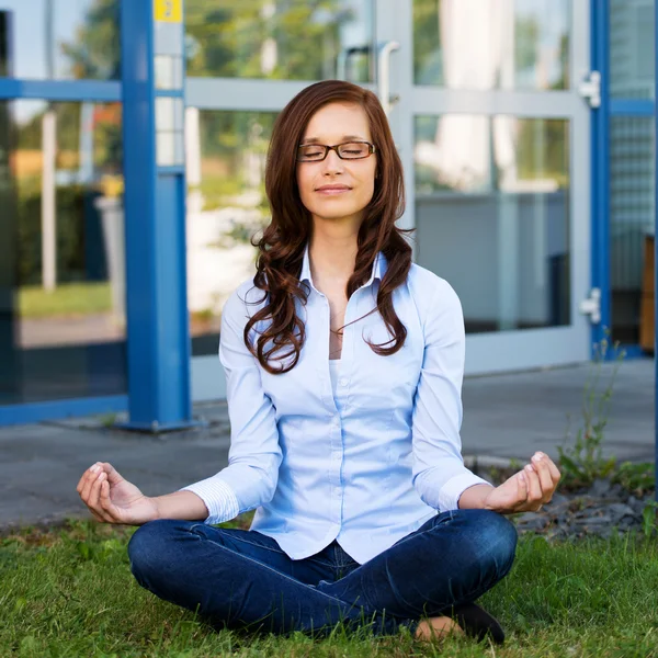 Молодая женщина сидит медитируя — стоковое фото