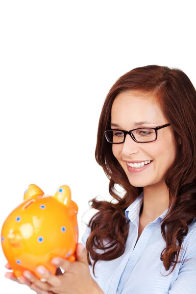 Attractive woman smiling at a piggy bank — Stock Photo, Image