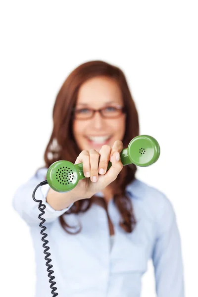 Femme souriante tenant un récepteur téléphonique — Photo