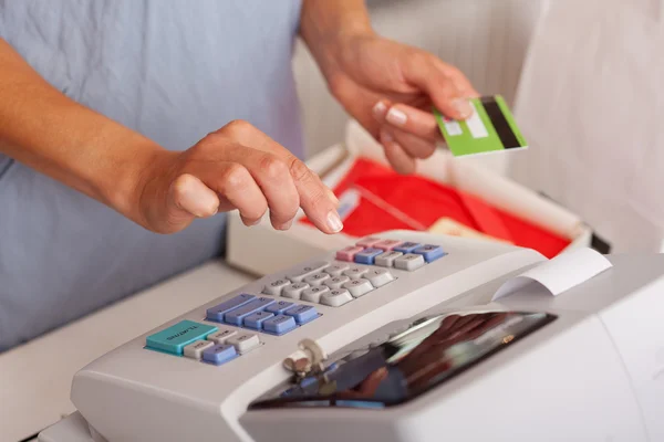 Πωλήτρια κρατώντας πιστωτική κάρτα ενώ χρησιμοποιώντας etr μηχανή — Φωτογραφία Αρχείου