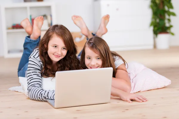 Two amused young teenage girls using a laptop — Stock Photo, Image