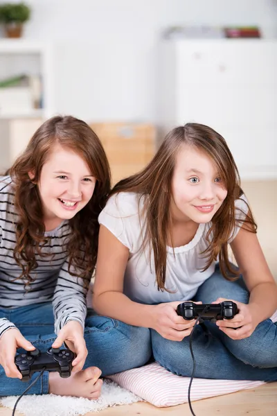 Duas meninas alegremente jogando jogos de vídeo — Fotografia de Stock