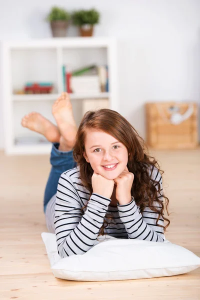 Smiling young teenage girl laying on the floor — Stock Photo, Image