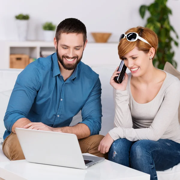 A fiatal pár használ Laptop és beszél telefonon — Stock Fotó