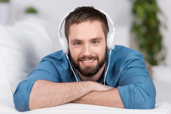 Young Man Lying On Sofa While Listening To Music — Stock Photo, Image