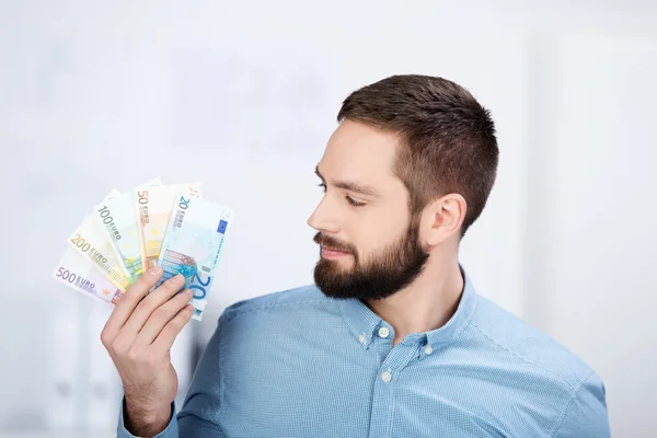 Empresário Segurando Olhando em notas de euro — Fotografia de Stock