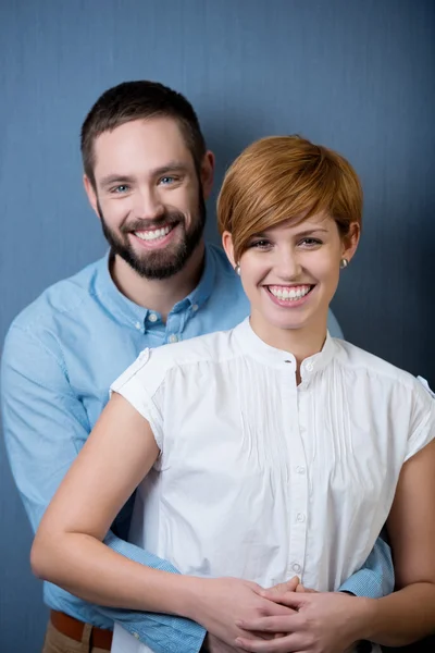 Casal rindo juntos sobre um fundo azul — Fotografia de Stock