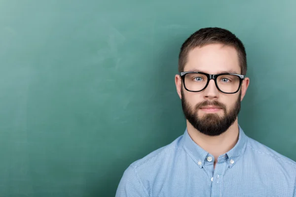 Student bär glasögon mot svarta tavlan — Stockfoto