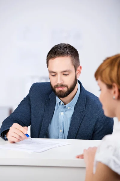 Explaining Documents To Female Co worker At Desk — Stock Photo, Image