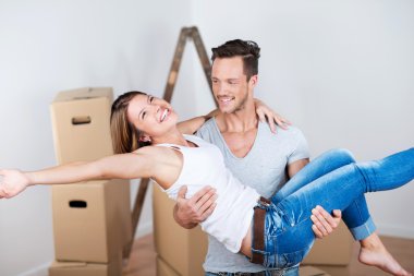 Joyful couple moving into their new home clipart