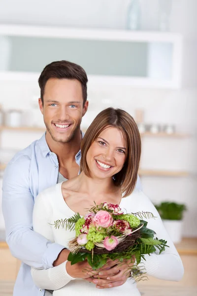 Smiling couple with flowers — Stock Photo, Image