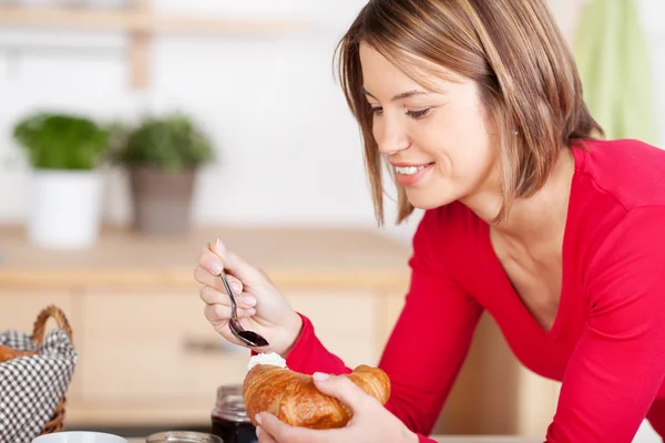 Woman eats a croissant — Stock Photo, Image