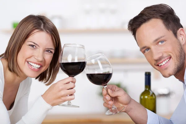 Улыбающаяся пара с бокалами красного вина — стоковое фото