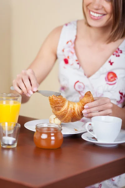 Mladá žena snídá v kavárně — Stock fotografie