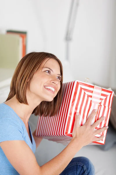 Sorrindo mulher sacudindo seu presente — Fotografia de Stock