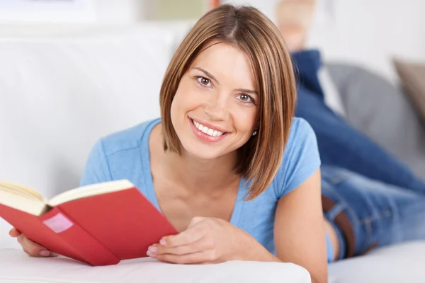 Gelukkig jonge vrouw genieten van een boek — Stockfoto