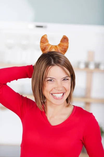 Playful woman with croissant horns — Stock Photo, Image